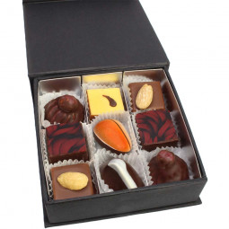 Verführerische Pralinen in schwarzer Box mit Rosenschleife